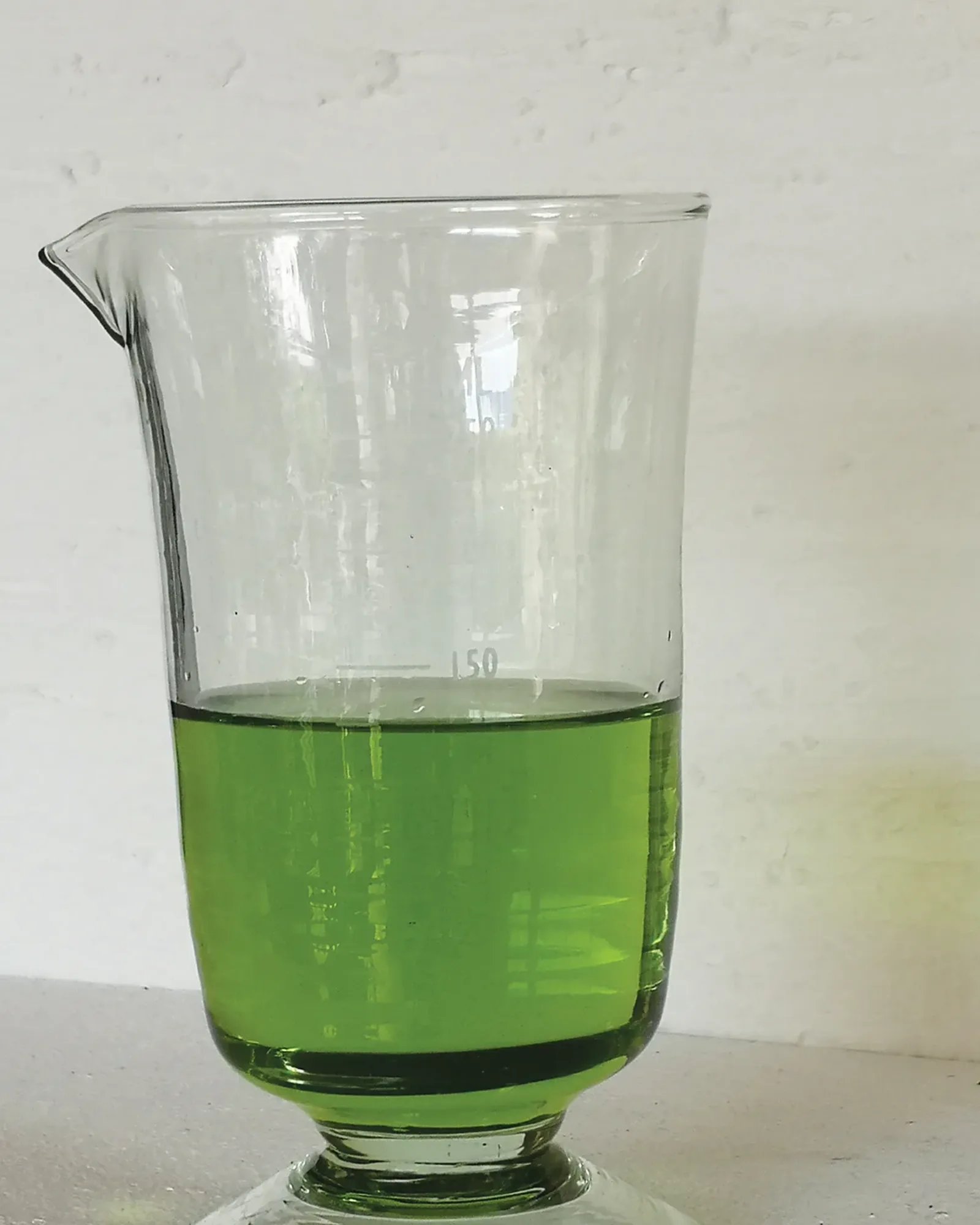A straight-sided glass in the style of a measuring glass, with a small posy of flowers in it.