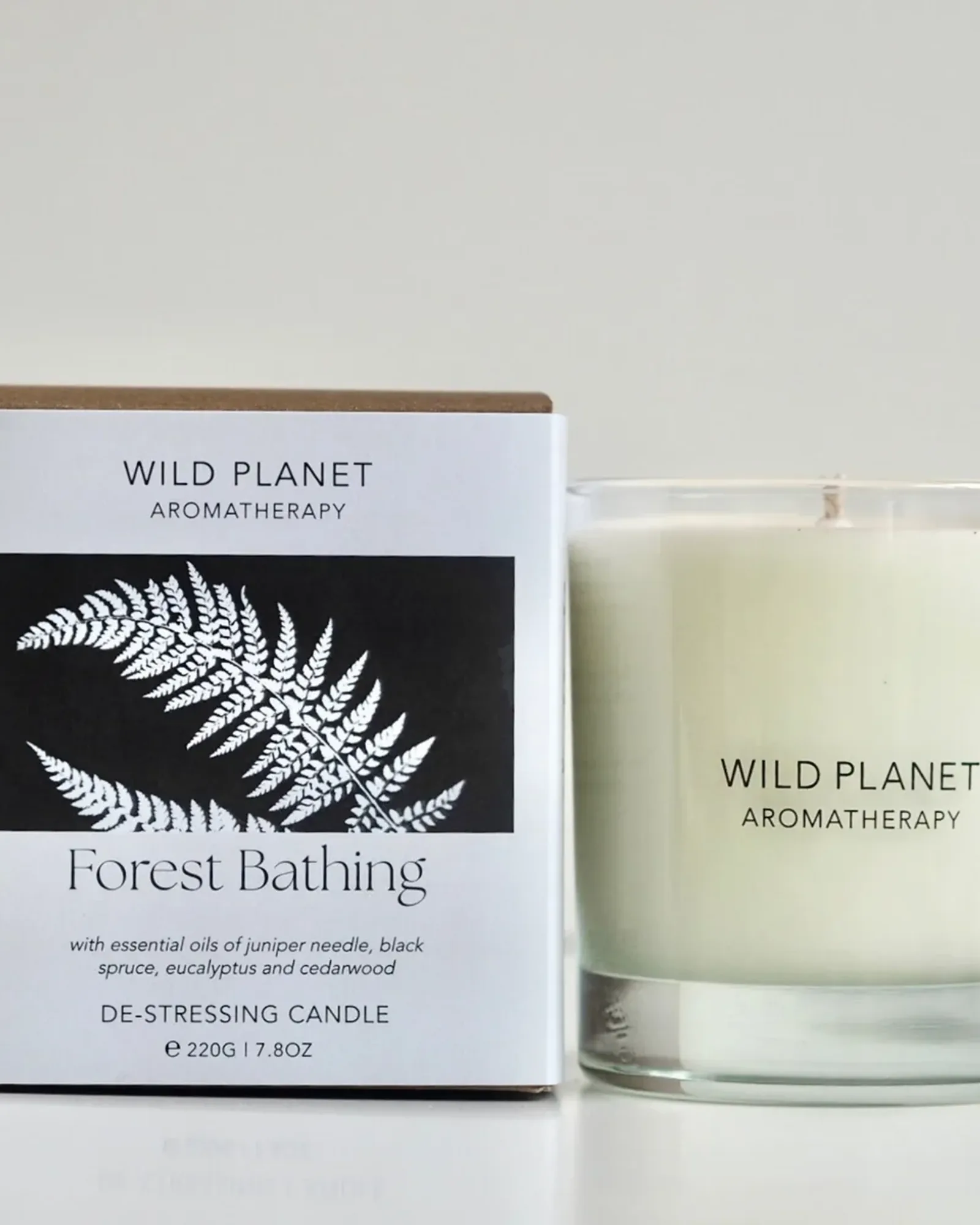 A Forest Bathing scented candle: soy wax with a single wick in a clear glass tumbler, beside its card box printed with the scent's name.