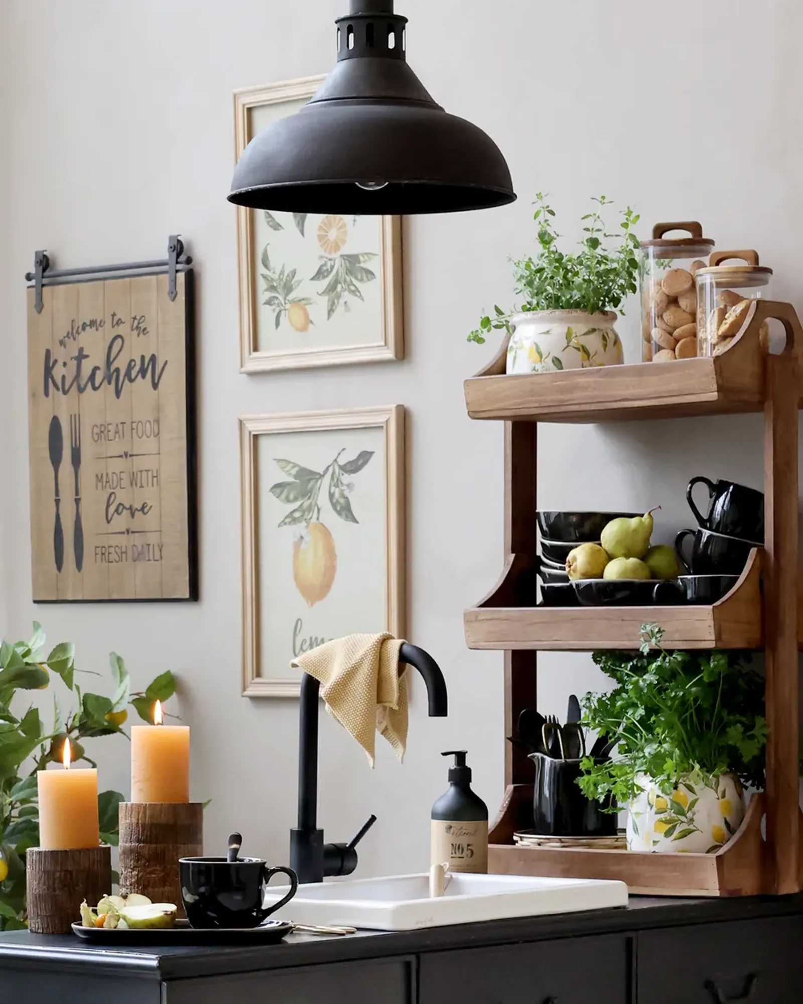 A three-shelf wall unit of natural recycled wood, dressed with jars and plants, on a kitchen wall.