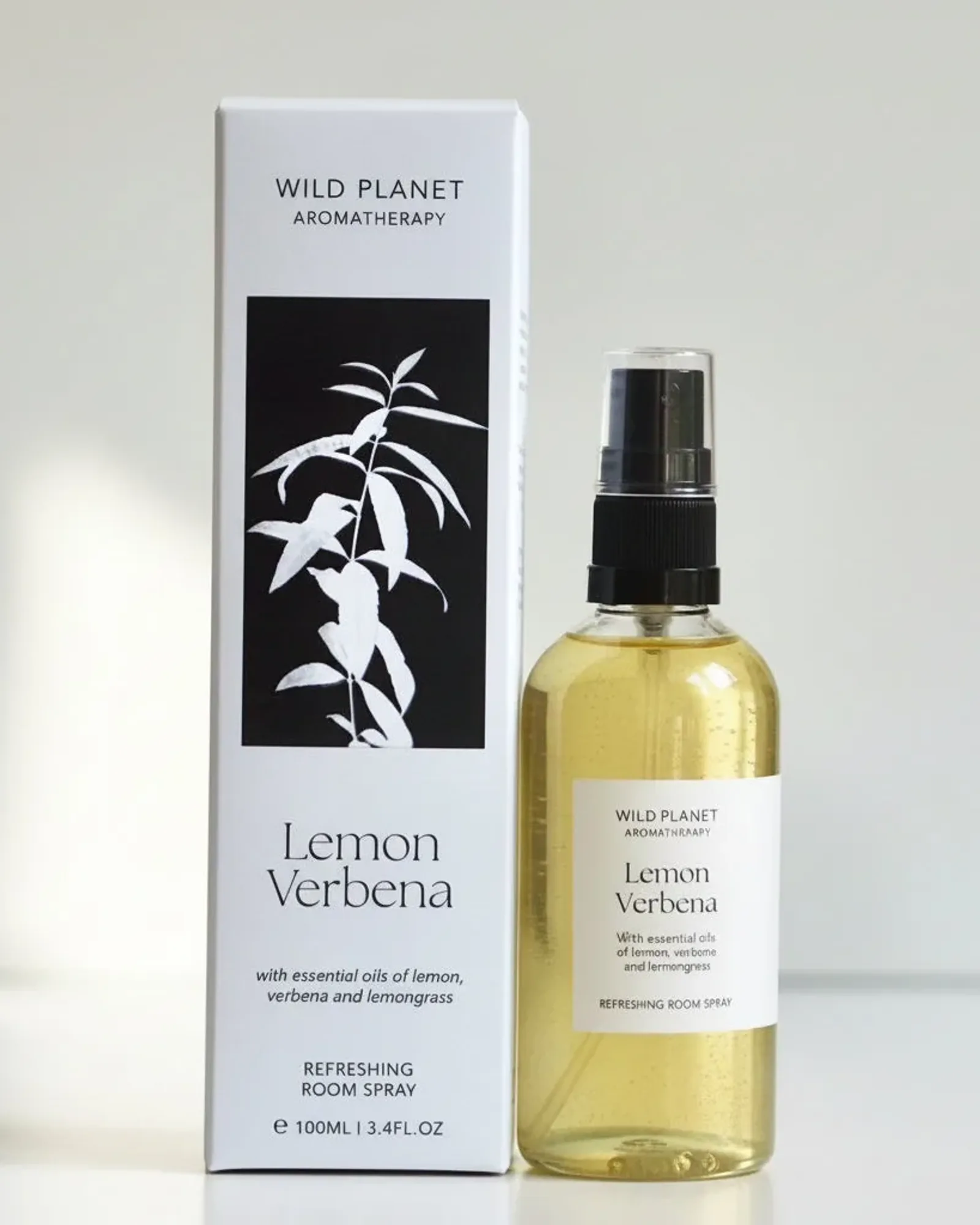 A clear glass bottle of Lemon Verbena room spray with a black spray pump and a small cream label naming the scent.