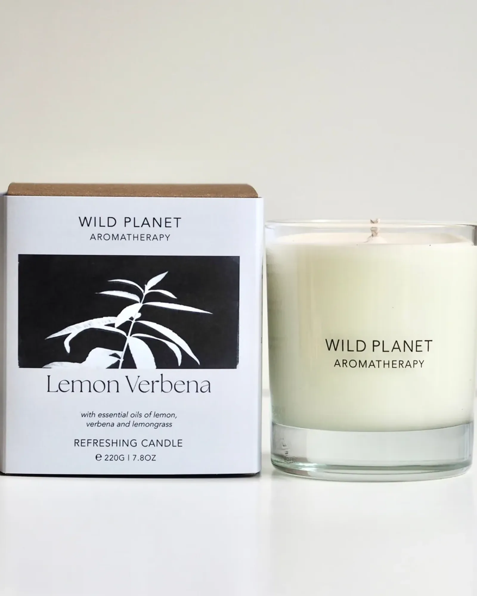A Lemon Verbena scented candle: soy wax with a single wick in a clear glass tumbler, beside its card box printed with the scent's name.