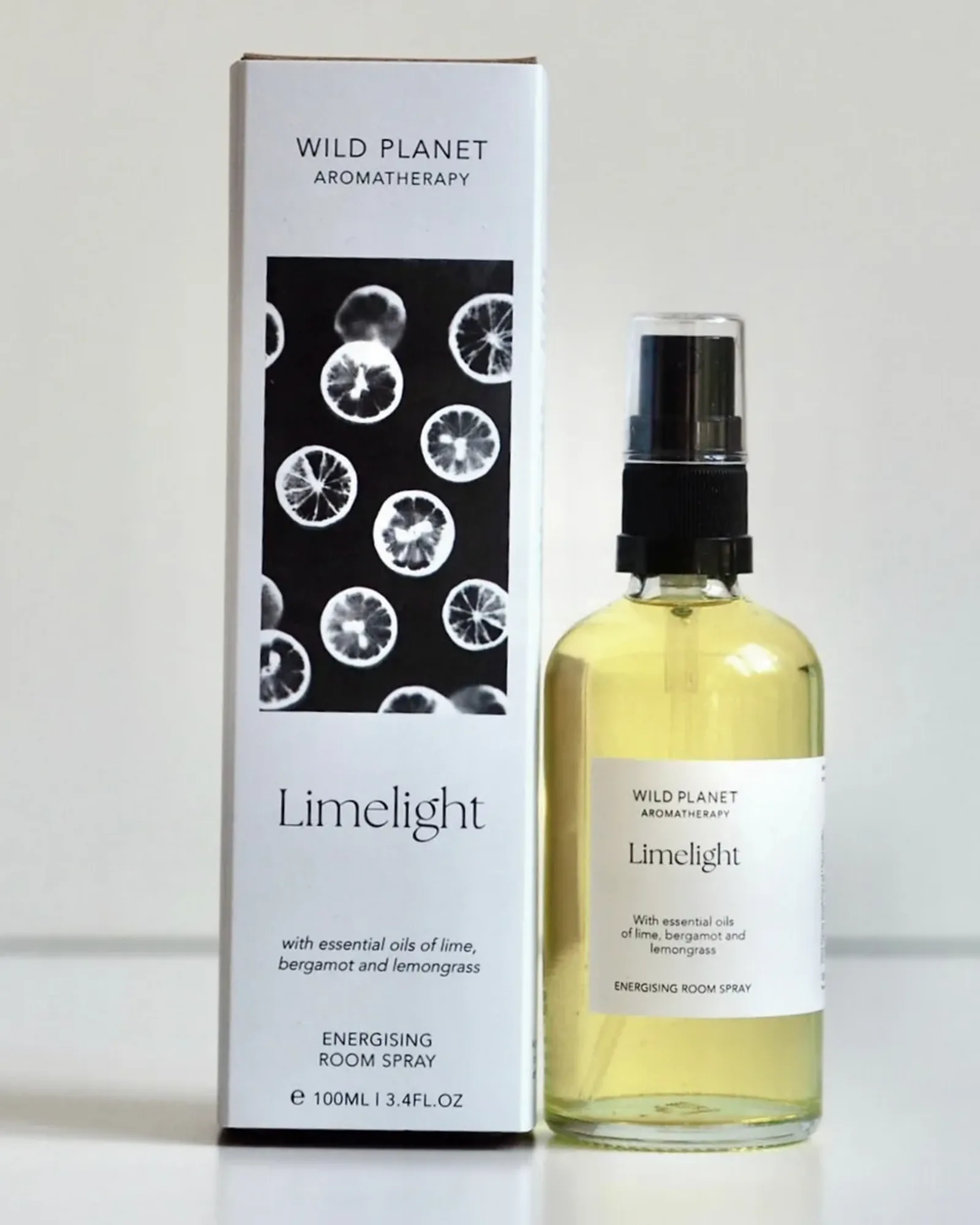A clear glass bottle of Limelight room spray with a black spray pump and a small cream label naming the scent.
