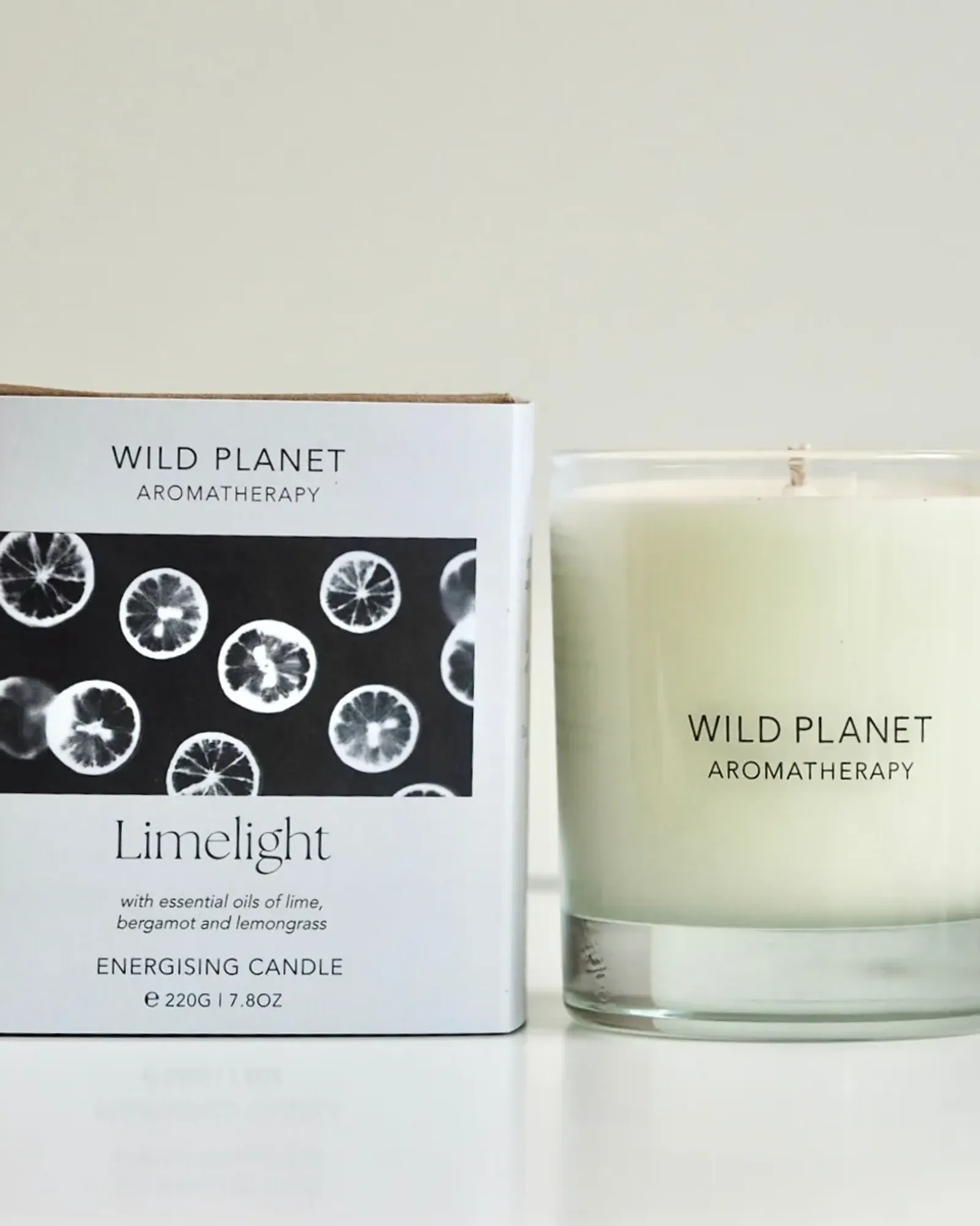 A Limelight scented candle: soy wax with a single wick in a clear glass tumbler, beside its card box printed with the scent's name.